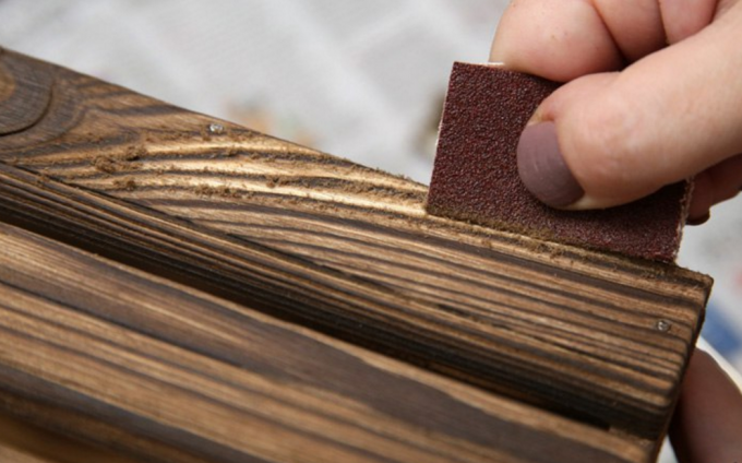 Kartáčované dřevo s brusným papírem. 